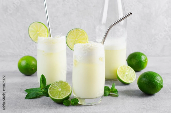 Fototapeta Brazilian Lemonade, Refreshing Creamy Lemonade or Limeade with Lime Slices and Mint on Grey Background