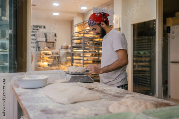 Obraz Arabic baker weighting dough with scale