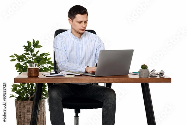 Fototapeta young man using laptop computer for online work at table