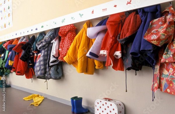 Fototapeta Coat rack in a nursery with a lot of children coats on a rack 