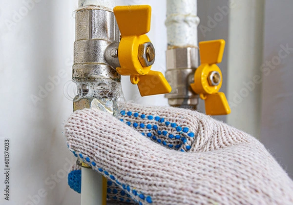 Fototapeta Gas leak at home. Inflating bubbles of soap mixture applied to the threaded joint on the gas pipe indicate a gas leak. Preventing a gas explosion disaster.