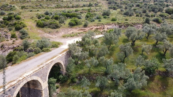 Obraz Tatar Bridge - Very old stone arch bridge from Ottoman or even older times about 30 m long with three arches, 2 central piers, completely preserved near Urla, Turkish Aegean Sea
