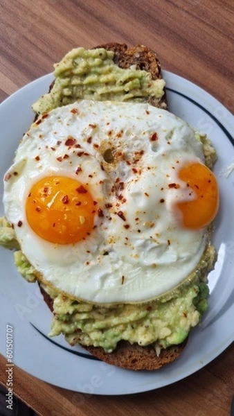 Fototapeta Bread with avocado and fried eggs