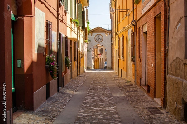Obraz Old street of Dozza with street art and arc with clocks.