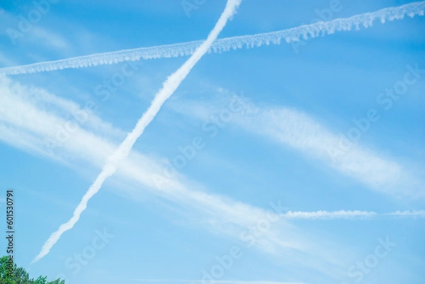 Fototapeta Art works of beautiful clouds over blue sky. Lines or cloud condensation traces arc across the sky. These sky art lines occur when aircraft exhaust condenses and clouds freeze. Ideal for designer 