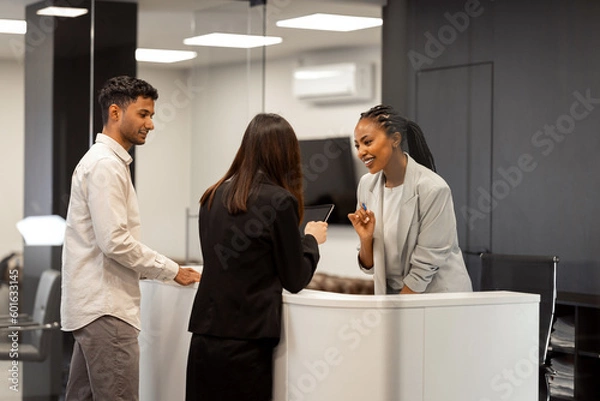 Fototapeta A group of multiethnic businesspeople meeting at the reception desk in the company.