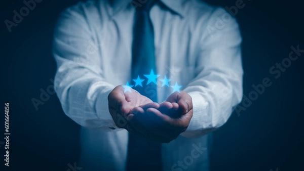 Fototapeta Concept Satisfaction and customer service. Businessman hand with five stars blue icon Display ratings, reviews, or positive experiences. and satisfaction from receiving excellent service