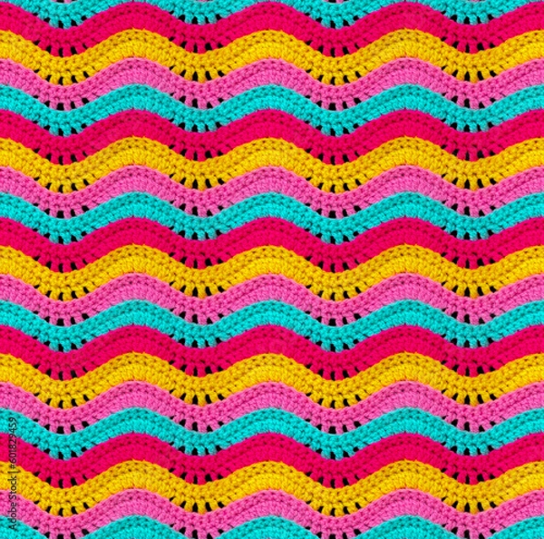 Fototapeta Seamless knitted pattern in the form of openwork waves is crocheted with threads of bright colors. Acrylic baby yarn. Volumetric style.