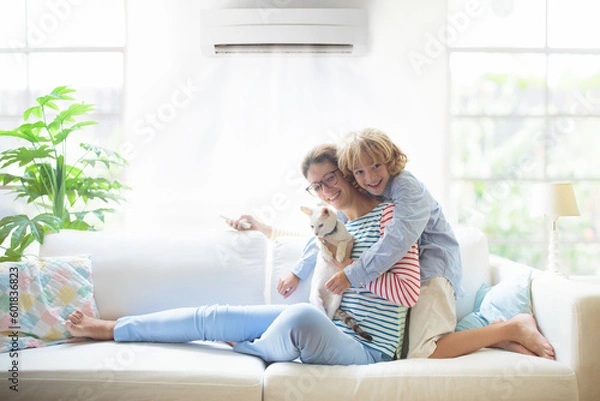 Fototapeta Mother and child with air conditioner remote