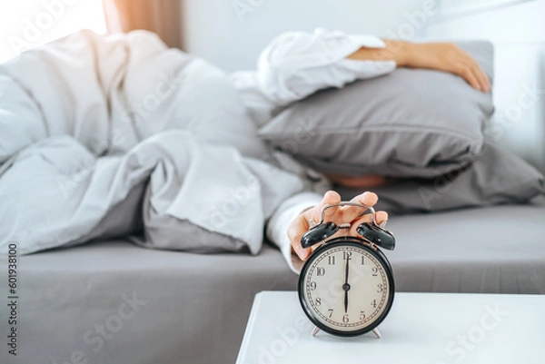 Fototapeta Close up Clock on the bed Asian woman wake up and disturbed by alarm clock early morning