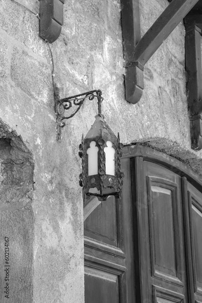 Fototapeta Black and white ancient vintage medieval design style metal pedant lamp hanging on the side of a brick wall in Rhodes city Old Town