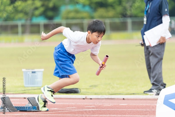 Fototapeta 陸上大会でリレーを走る小学生の男の子