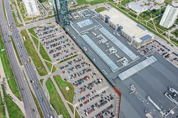 Fototapeta aerial view of shopping mall with crowded parking lot and highway nearby