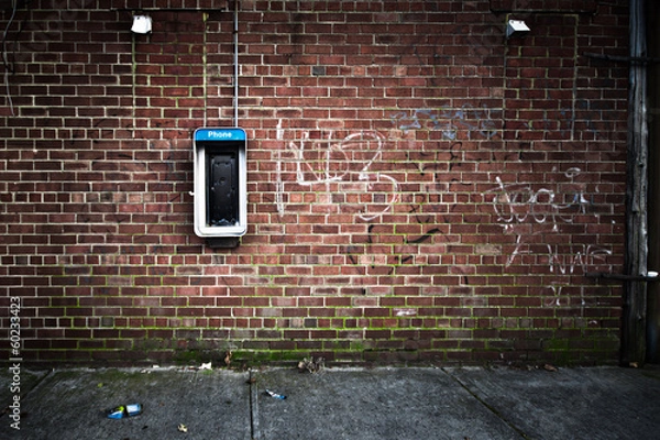 Obraz Nieczysty mur miejski ze starym automatem telefonicznym