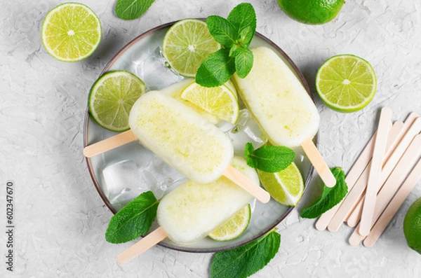 Fototapeta Refreshing Lime Popsicles, Brazilian Lemonade Ice Lolly with Fresh Lime and Mint on Bright Background