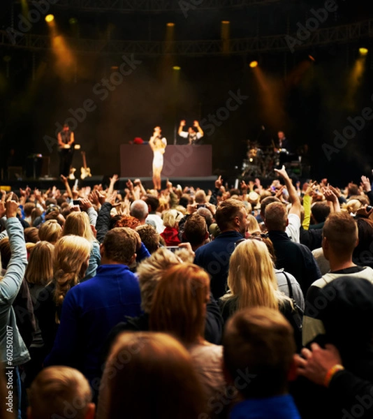 Fototapeta Dance, music and stage with crowd at festival for concert, dj show and rave performance. Rock, energy and hands of people dancing in audience for party celebration, disco and techno event