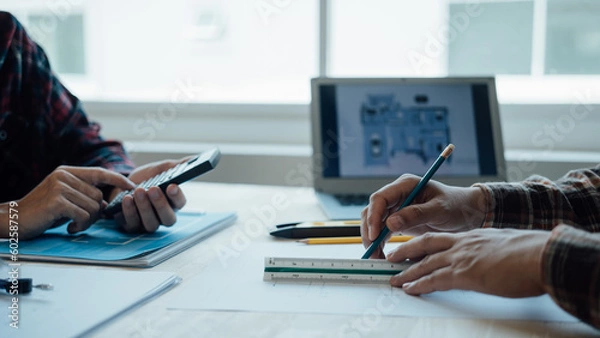 Fototapeta Architecture Interior designer working with building apartment plans blueprints on desk table at construction site office, closeup.