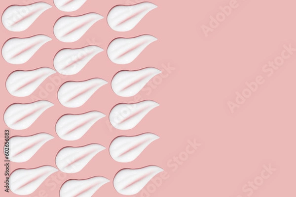 Fototapeta Lots of smears of cosmetic cream. Light, smooth surface. Texture of spreadable cream. Liquid creamy strokes. On a pink background. Cosmetic background, banner.