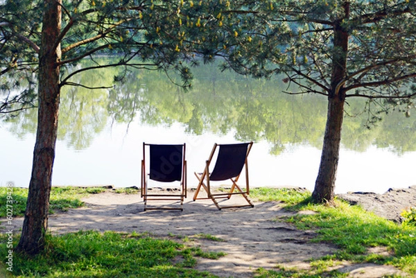 Fototapeta Two empty chairs near river.