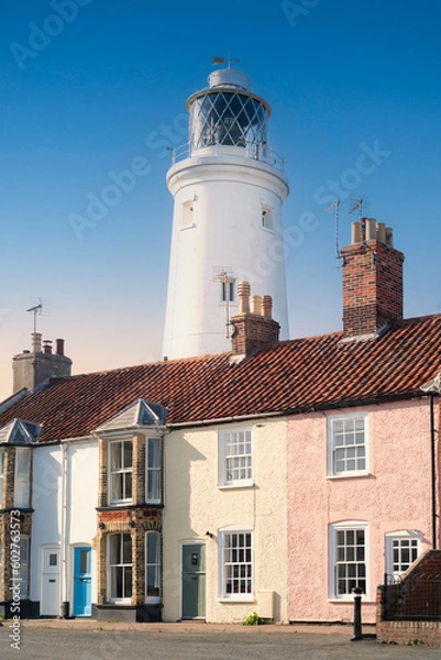 Fototapeta The lighthouse behind and towering above houses in the seaside town of Southwold in Suffolk, uk.