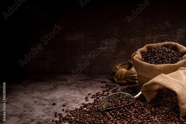 Obraz The picture of coffee beans stacked together on a wooden floor in a warm, light atmosphere, on a dark background, with copy space.