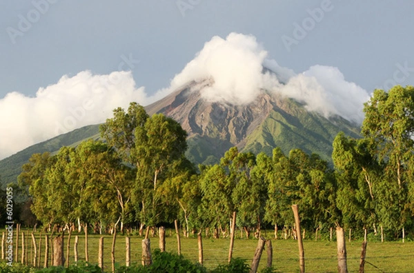 Obraz An active volcano looms  over rich, fertile fields below