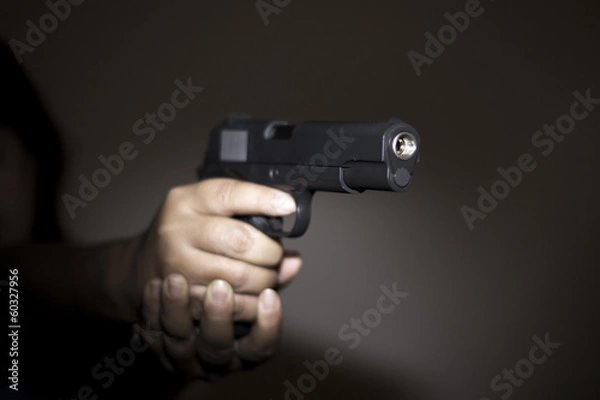 Obraz Hand holding gun preparing to fire