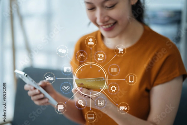 Fototapeta Hands holding credit card and using smartphone in home. Online shopping.