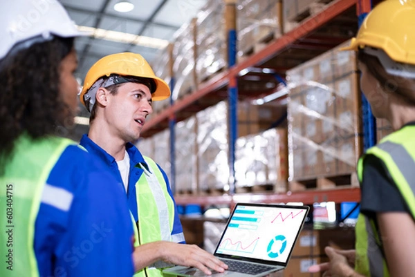Fototapeta Diversity of Warehouse staff wearing a protective face mask in safety suite using apps on digital tablet checking and receiving items goods for storage in the warehouse, modern smart logistic industry