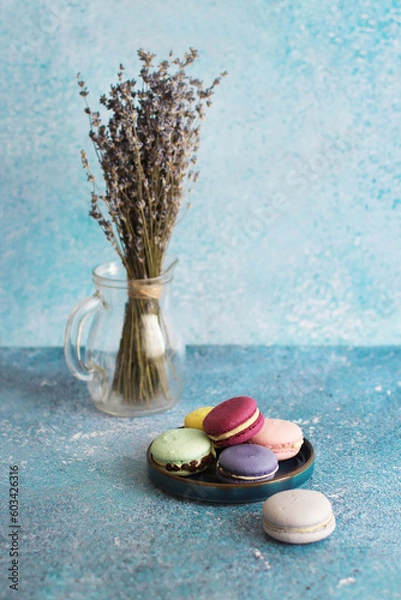 Fototapeta Colored macaroons on turquoise background and bouquet of lavender on background