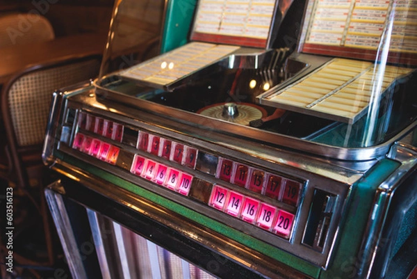 Fototapeta Vintage American music jukebox with illuminated buttons, process of choosing song composition, retro old-fashioned juke-box with vinyl discs musical box machine in cafe diner restaurant