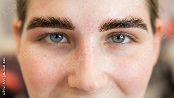 Fototapeta Close-up portrait of a woman after the procedure of correction and lamination of eyebrows. 