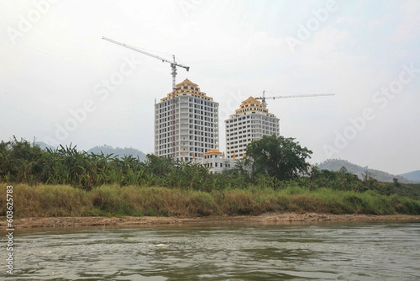 Obraz Massive out-of-place ongoing construction next to the Laotian border entry post by the Thai-Lao Friendship Bridge IV, seen from the Mekong River, Laos.