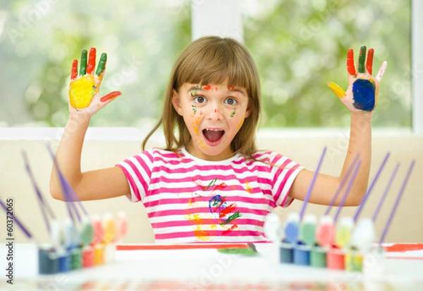 Obraz Little girl is drawing using pencils