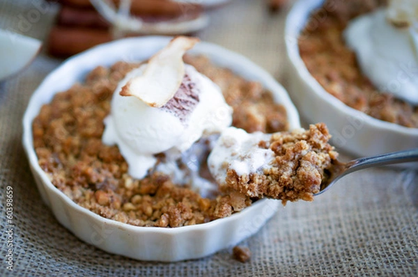 Fototapeta Apple crumble dessert with cinnamon and vanilla ice -cream on wo