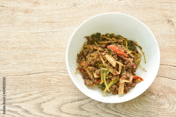 Fototapeta spicy stir fried bamboo shoot and chop beef meat with basil leaf in bowl