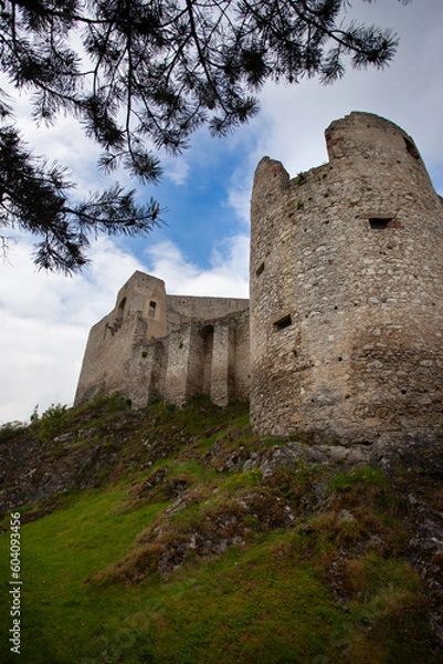 Fototapeta Low angle view of the circular tower of a castle in ruins. Architectural parts of a castle in ruins, the fortified circular tower and the walls.