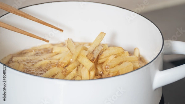 Fototapeta フライドポテト(細切り)を揚げる　調理シーン