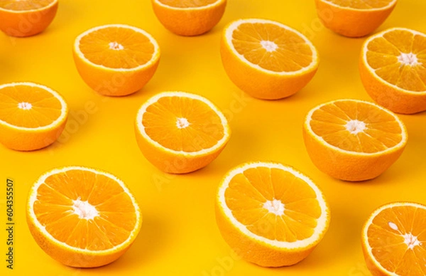 Obraz Oranges Cut In Half On A Yellow Background