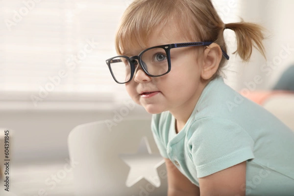 Fototapeta Cute little girl in glasses at home. Space for text