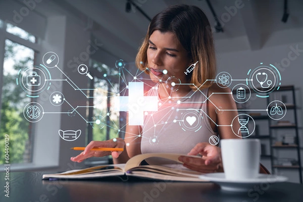 Fototapeta Smiling woman in casual wear taking notes in notebook at office workplace with coffee cup. Concept distant business education, information technology, dreaming, thinking. Health care medical drawings