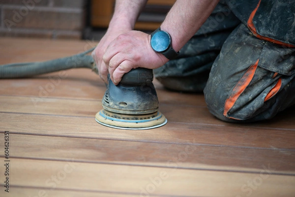Obraz Sanding process of wooden terrace floors. Sanding machine remove imperfections.