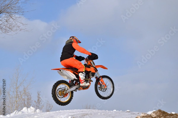 Obraz MX rider on the bike jumps from a hill on a snowy highway