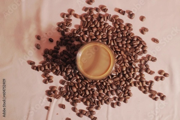 Obraz Cup of coffee with and coffee beans on peach color background. Creative layout. Breakfast concept. Top view, flat lay