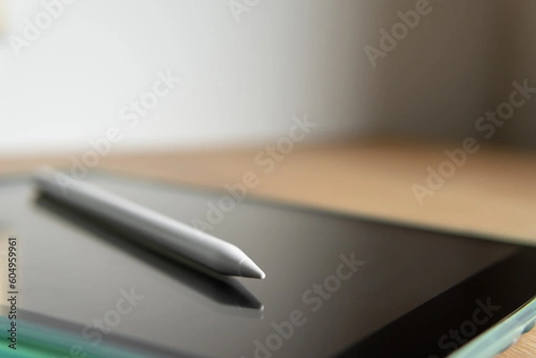 Fototapeta tablet and pencil close-up with blurred background.