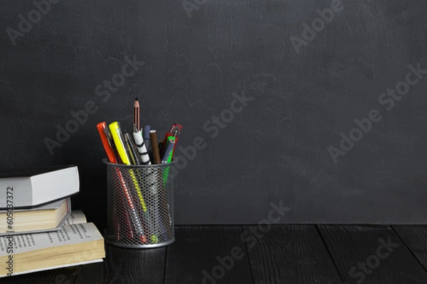 Fototapeta School and education concept.Copy space. Chalk board and old books. Pens and pencils in a bucket.Chalk rubbed out on blackboard. Chalkboard background