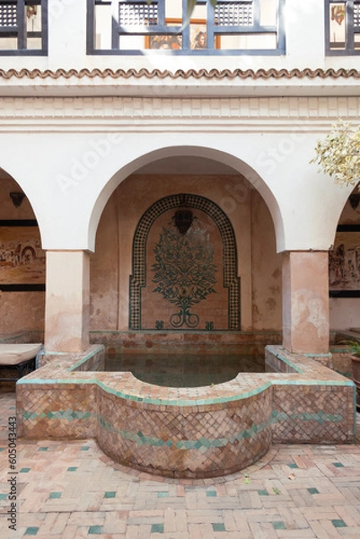 Fototapeta Moroccan indoor bath or pools with moorish arches, arabic tiles and architecture in the interior terrace of a riyad in Marrakech, Morocco.