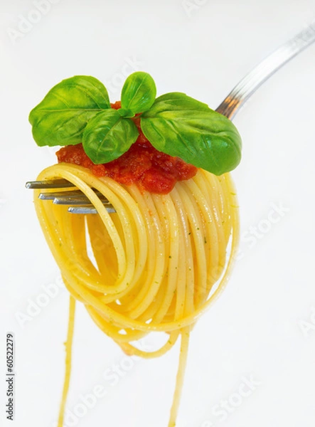 Obraz Spaghetti na widelcu z bazylią i sosem na białym tle.