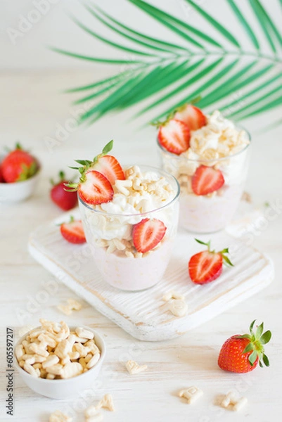 Obraz Desserts of cookies and whipped cream with strawberries in glasses, background and foreground in blur
