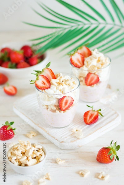 Obraz Desserts of cookies and whipped cream with strawberries in glasses, background and foreground in blur